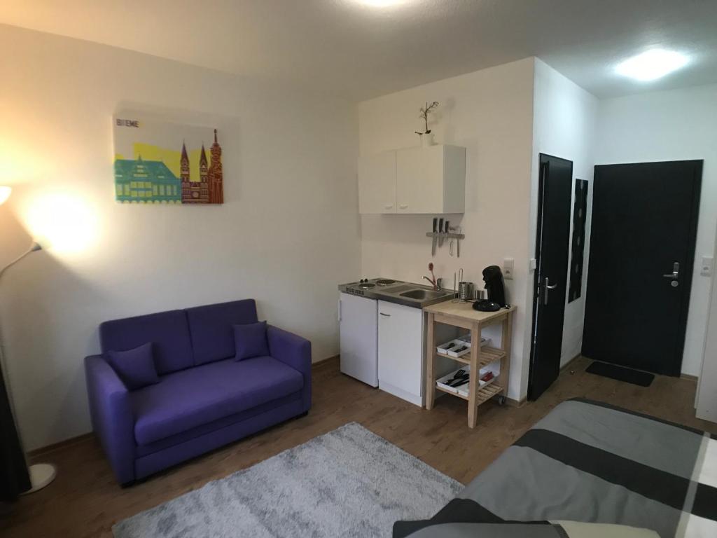 uma sala de estar com um sofá roxo e uma cozinha em Living @ Klassvilla Weserwehr No. 3 em Bremen