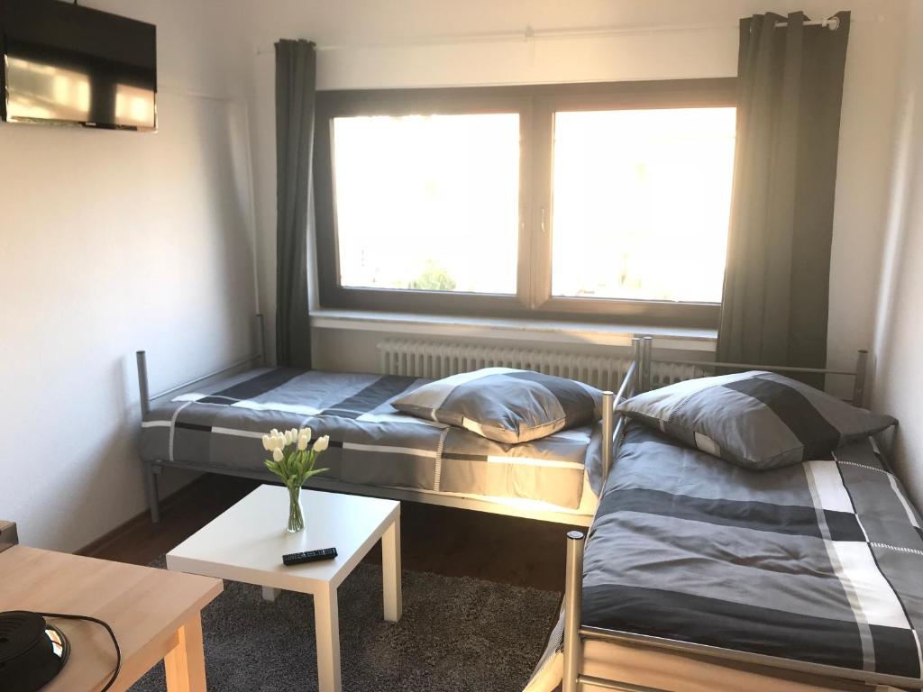ein Zimmer mit zwei Betten und einem Tisch und einem Fenster in der Unterkunft Living @ Klassvilla Weserwehr No. 4 in Bremen