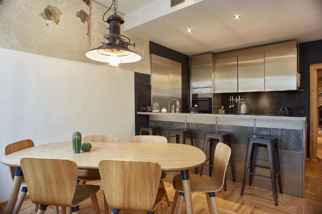 kuchnia i jadalnia z drewnianym stołem i krzesłami w obiekcie Casa Spinetta Malaspina - Verona Apartments w Weronie