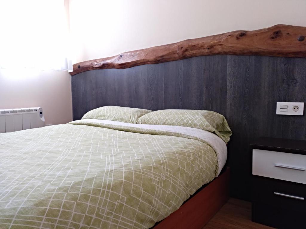 レオンにあるApartamento Santa Cruzのベッドルーム1室(木製ヘッドボード付)