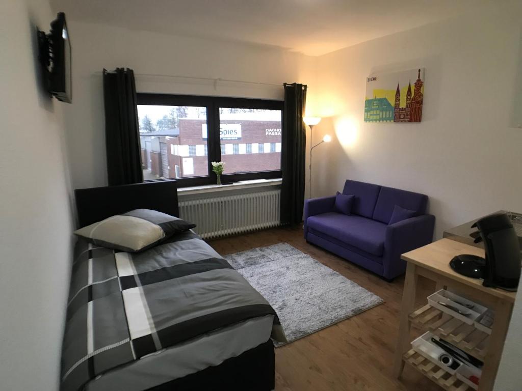ein Schlafzimmer mit einem Bett, einem Sofa und einem Fenster in der Unterkunft Living @ Klassvilla Weserwehr No. 5 in Bremen