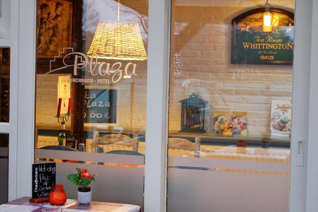 a pizza shop window with a sign on the wall at Hotel Plaza in Lommel