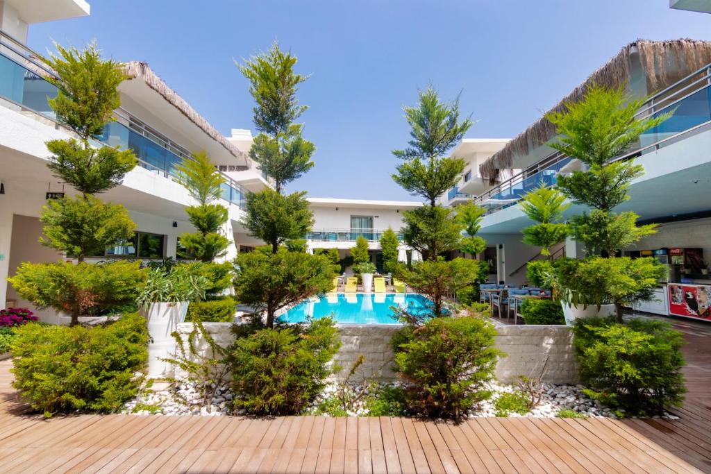 an apartment complex with a swimming pool and trees at The D Hotel Çeşme Resort in Çeşme