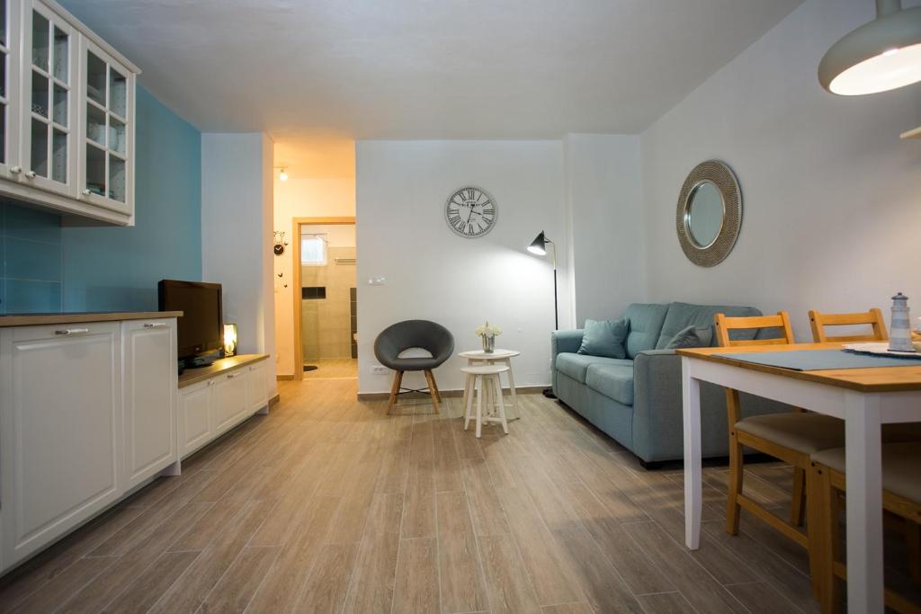 ein Wohnzimmer mit einem blauen Sofa und einem Tisch in der Unterkunft Cozy Coastal apartment GaMa in Split
