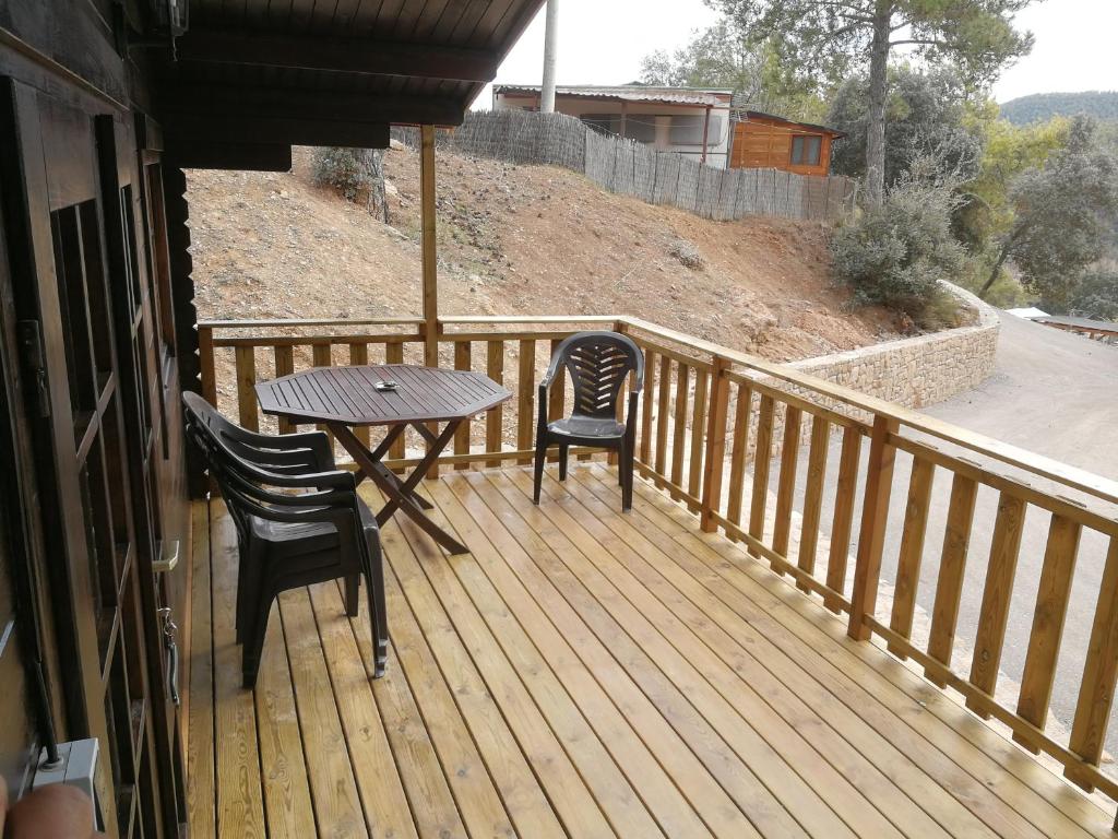 une terrasse en bois avec une table et des chaises. dans l'établissement Camping La Ribera Salada, à Ogern