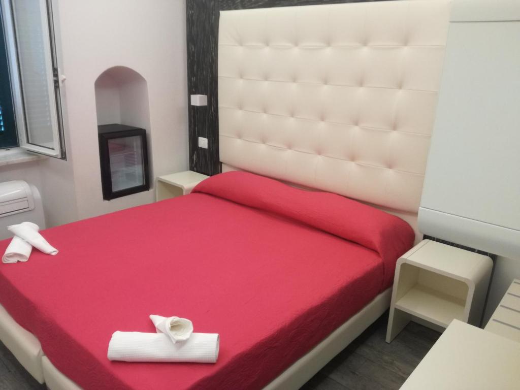 Un dormitorio con una cama roja con dos cajas blancas. en Zia Rita en Riomaggiore
