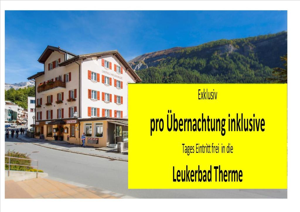 a yellow sign in front of a building at Hotel Heilquelle in Leukerbad