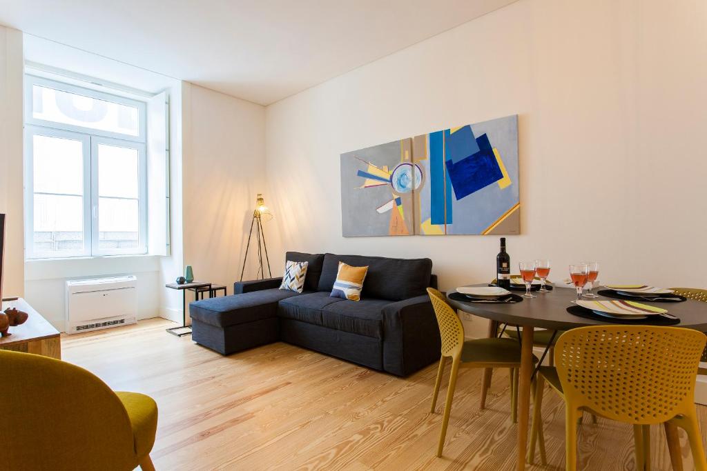 uma sala de estar com um sofá e uma mesa em JOIVY Modern 1-bed Apt nearby Praça do Comércio, in Baixa em Lisboa