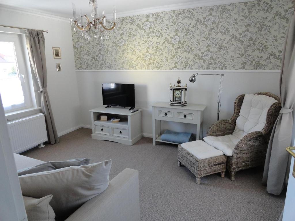 ein Wohnzimmer mit einem TV und 2 Stühlen in der Unterkunft Cottage Ferienwohnung mit Seeblick in Caputh