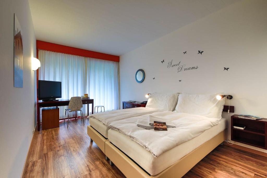 a bedroom with a bed and a desk and a television at Hotel Serpiano in Serpiano