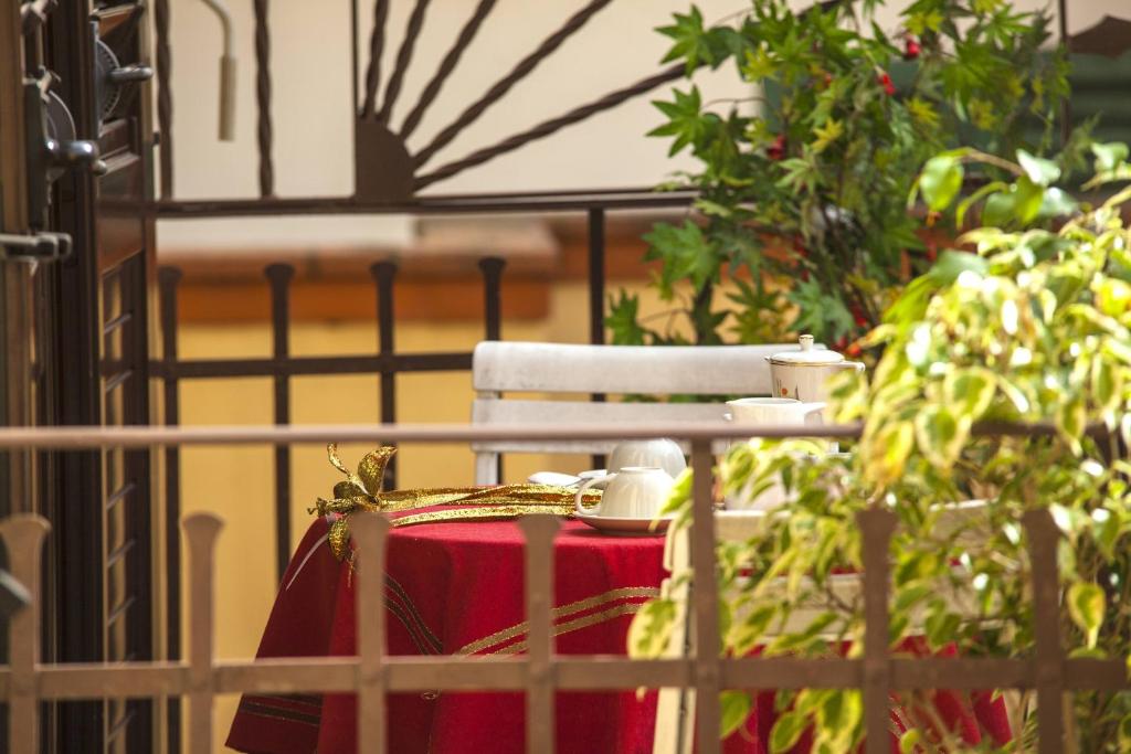 フィレンツェにあるホテル ヴィラ イル カスターニョの赤いスーツケースが柵の上に座っている