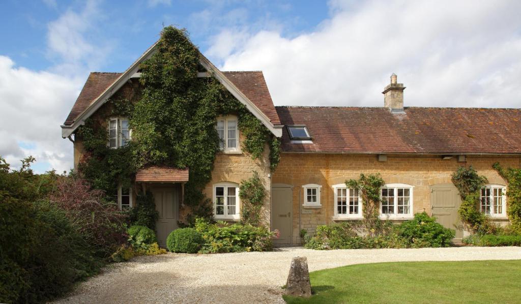 a large brick house with ivy growing on it at Epsom Cottage in Bruern