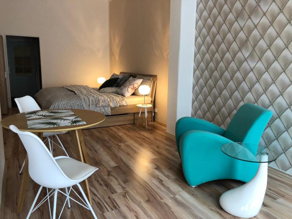 um quarto com uma cama, uma mesa e cadeiras em Apartmány Galeta em Karlovy Vary