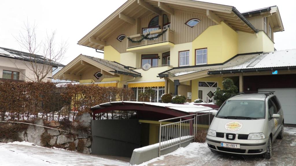 ein Van vor einem Haus im Schnee geparkt in der Unterkunft Villa Theresa in Kaprun