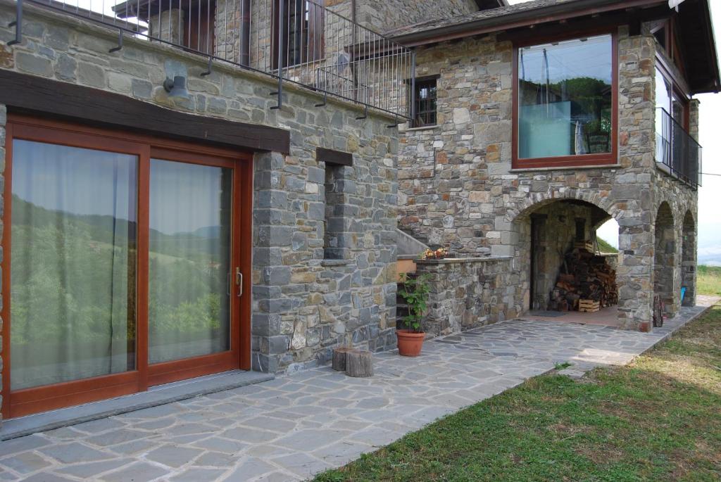 a stone house with a door and a fireplace at Il Paradiso monolocale Cottage in Albareto