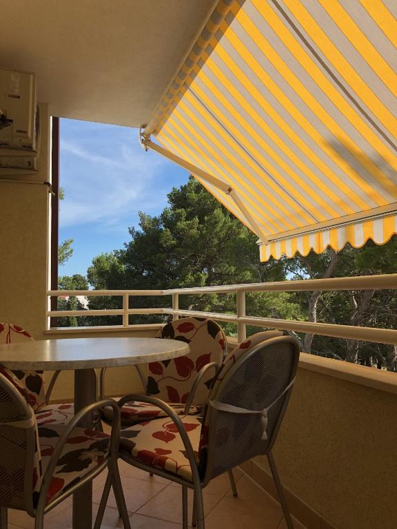 a balcony with a table and chairs and a window at Apartment Sanja in Baška Voda