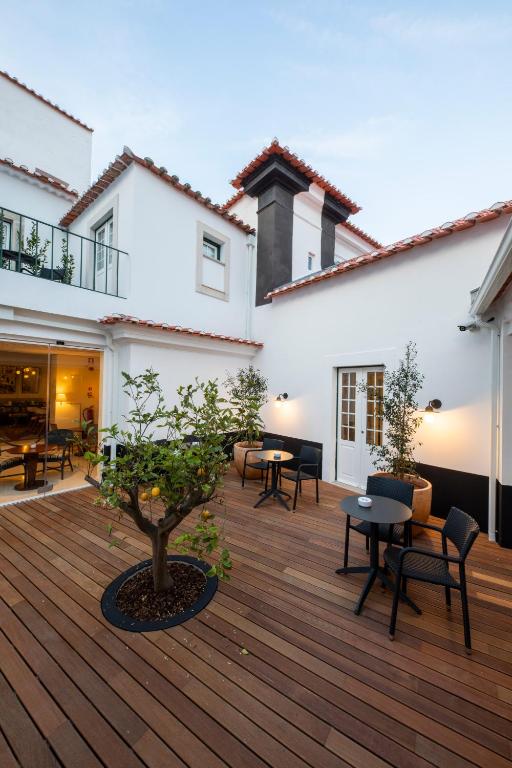 a patio with tables and chairs on a wooden deck at Pousada Vila Óbidos in Óbidos