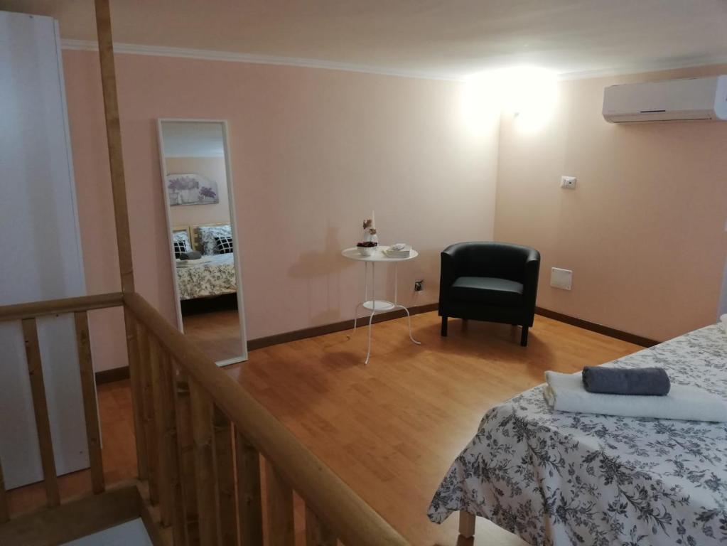 Pokój z łóżkiem, krzesłem i lustrem w obiekcie Casa Vacanza Due Effe w mieście Martina Franca