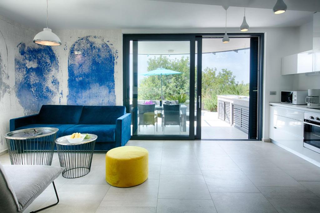 a living room with a blue couch and a yellow stool at Villa Periska Komiža in Komiža