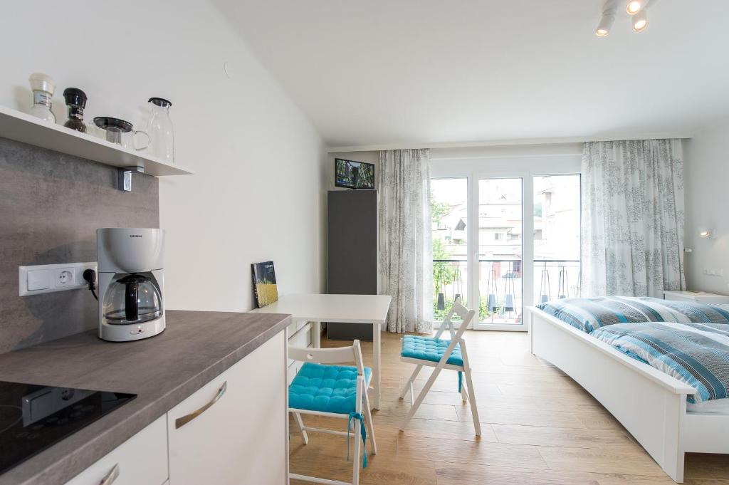 a kitchen and a bedroom with a bed and a table at Apartements Kaschitz in Pörtschach am Wörthersee