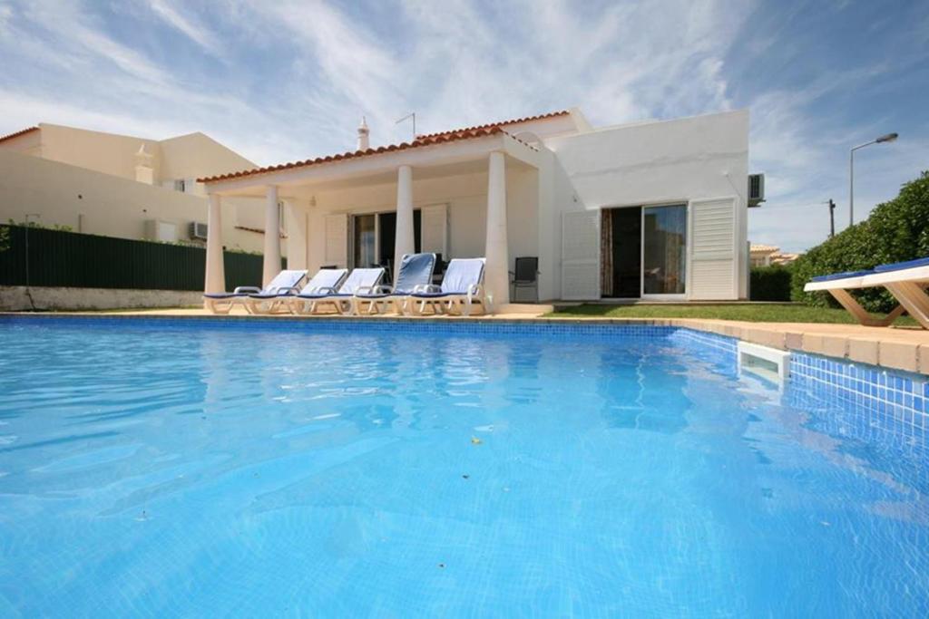 a swimming pool in front of a house at Villa 300m from Beach in Albufeira