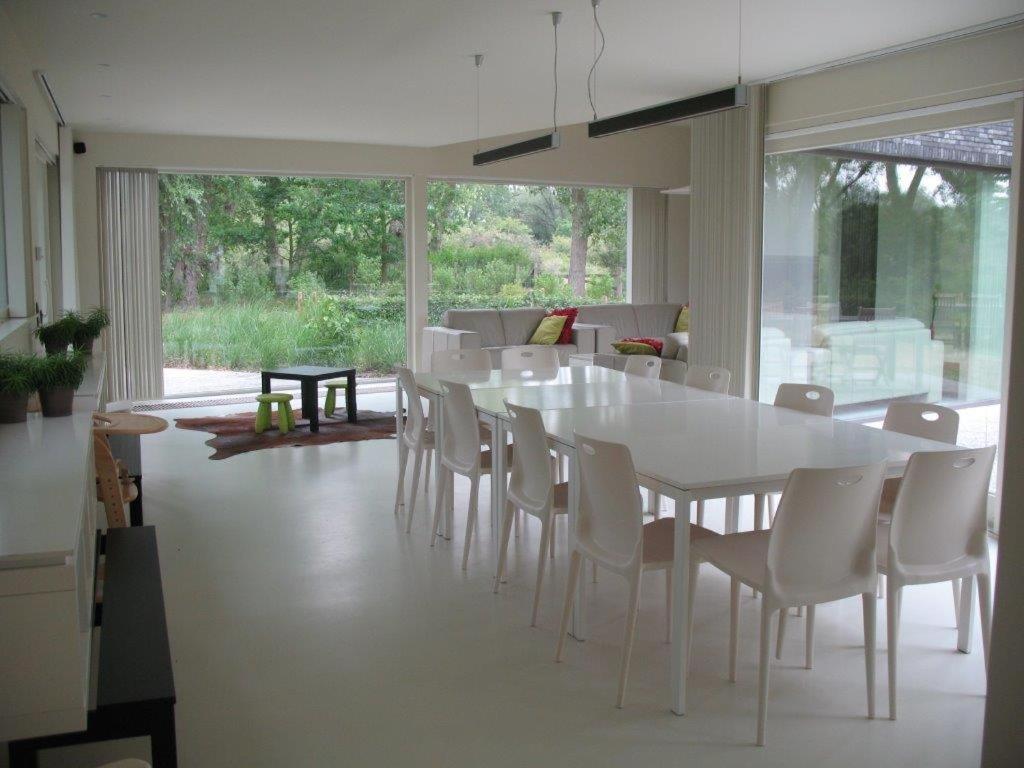 a dining room with a white table and chairs at Duinpaviljoen in Koksijde