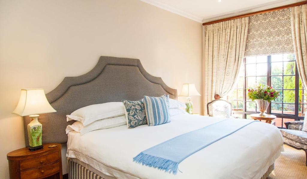 Un dormitorio con una gran cama blanca y una ventana en Ivory Manor Boutique Hotel en Pretoria