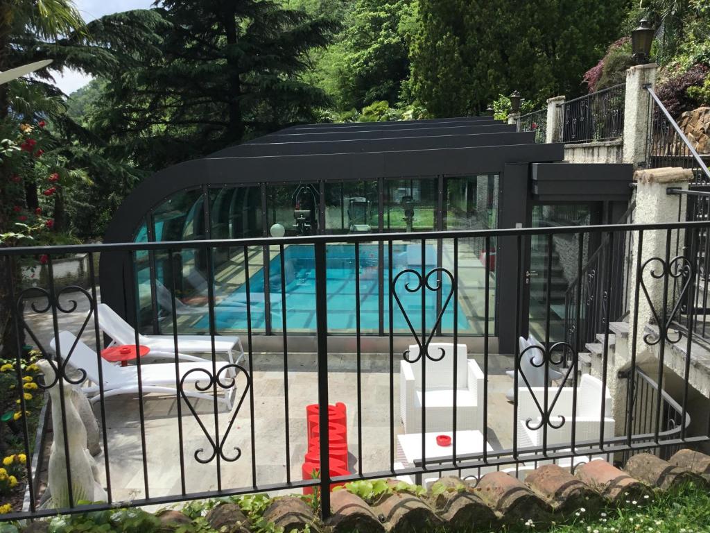 una valla con una piscina en el fondo con una piscina en Mon Amour appartamento in villa vista lago a Lugano-Melide, en Melide