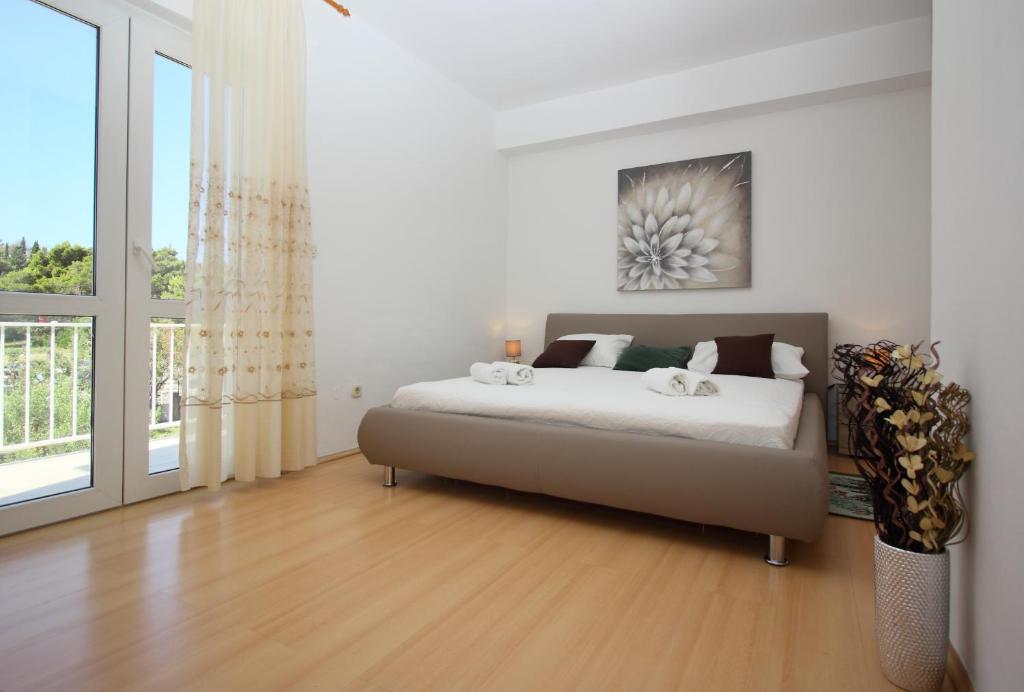 a bedroom with a bed and a large window at Apartments Dubrovnik-Cavtat in Cavtat