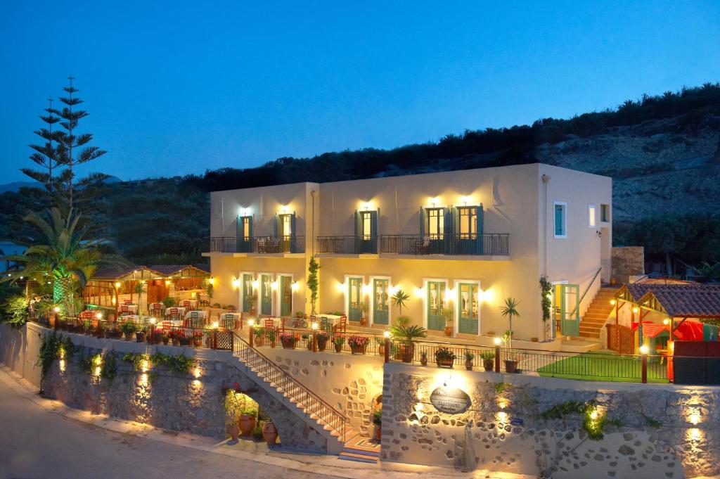 un bâtiment avec des lumières devant lui la nuit dans l'établissement Kaliviani Traditional Hotel, à Kíssamos