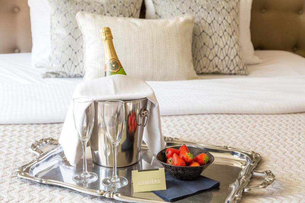 a tray with a bottle of champagne and a bowl of strawberries at Boutique Hotel Lumiere in Eindhoven