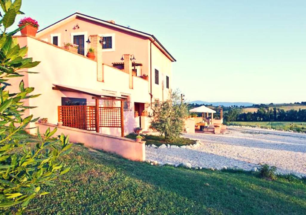 a house on a gravel road next to a building at Casale Molinelle in San Gemini