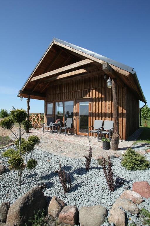 a log cabin with a table and chairs in front of it at Atomiņi in Aucugals