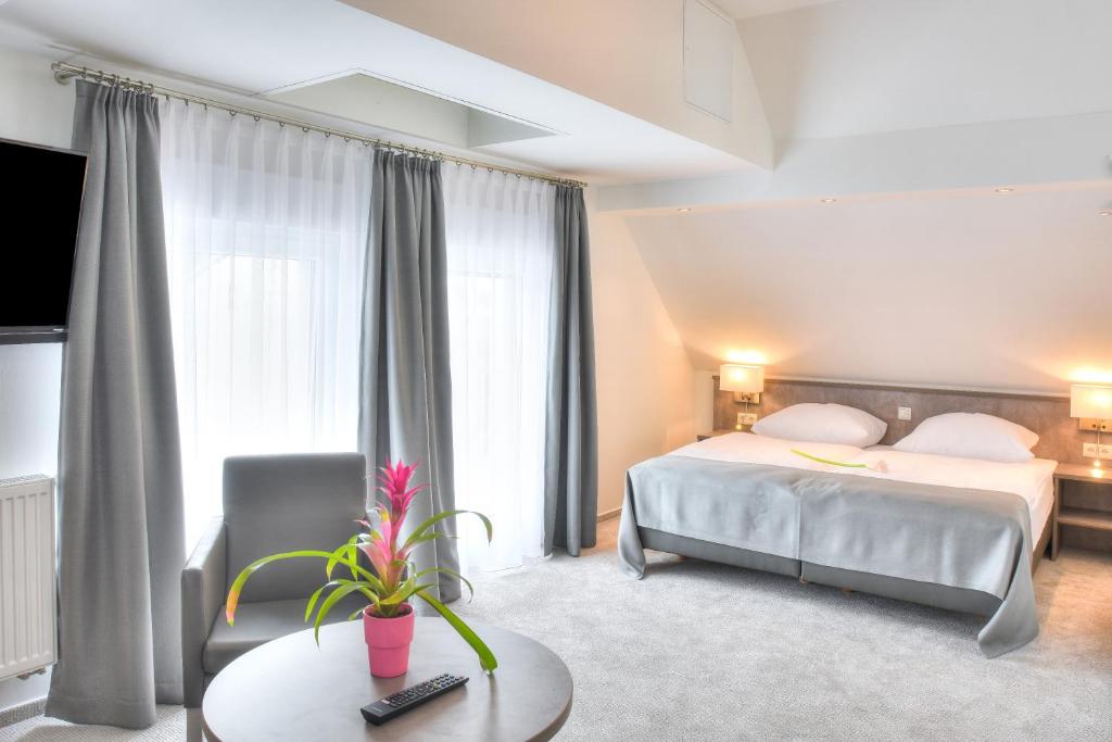 een hotelkamer met een bed en een tafel bij Fast Lane Hotel in Barweiler