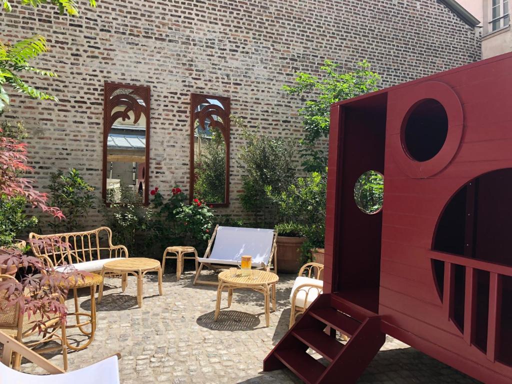 a patio with chairs and tables and a brick wall at ibis Styles Paris Nation Cours de Vincennes in Paris