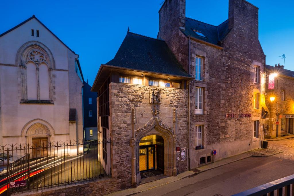 un vieux bâtiment en briques avec une arche dans une rue dans l'établissement Hotel Arvor - O'Lodges by Arvor, à Dinan