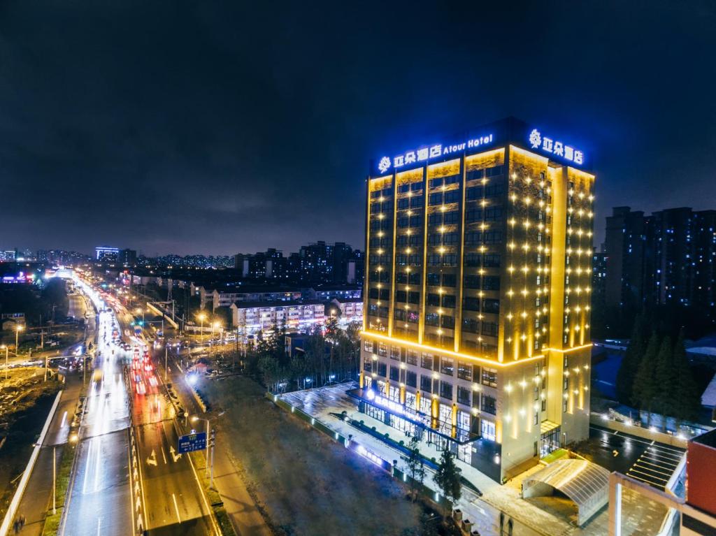 un edificio illuminato su una strada cittadina di notte di Atour Hotel (Shanghai International Tourism and Resorts Zone XiuYan Road) a Shanghai