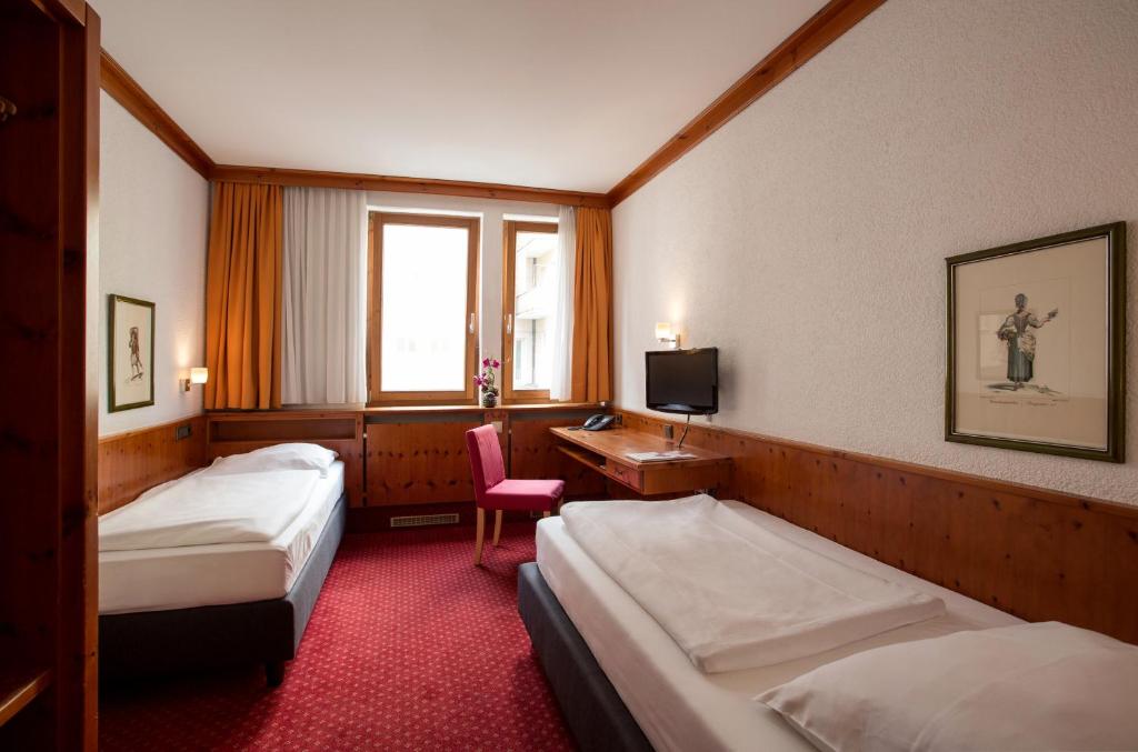 ニュルンベルクにあるシュティシェーレ ホテル＆ヴァインレストランのベッド2台とデスクが備わるホテルルームです。