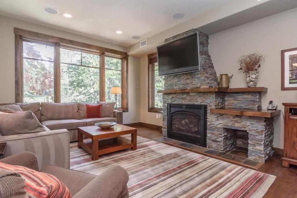a living room with a couch and a fireplace at Woodwinds 25 in Mammoth Lakes