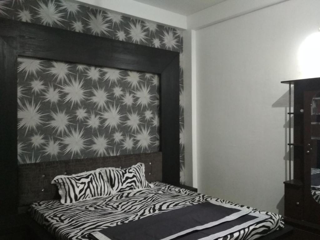 a bedroom with a bed with a zebra print headboard at Ashta Lakshmi Tourist Home Stay in Indore
