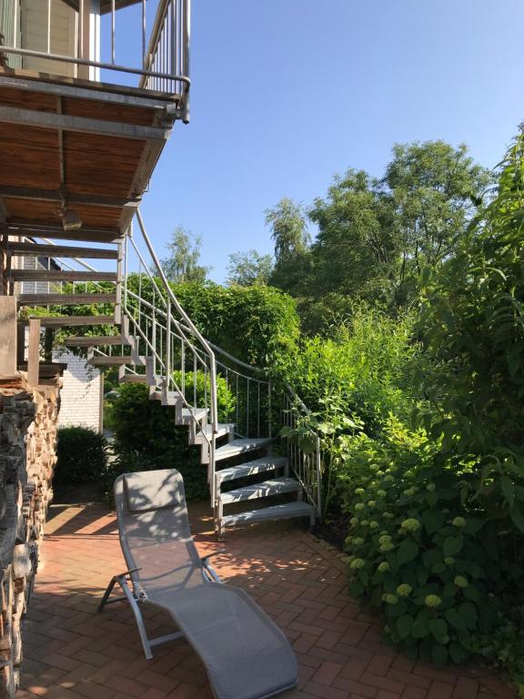 une chaise posée sur une terrasse en briques à côté d'un escalier dans l'établissement Ferienwohnung Landart, à Hilter