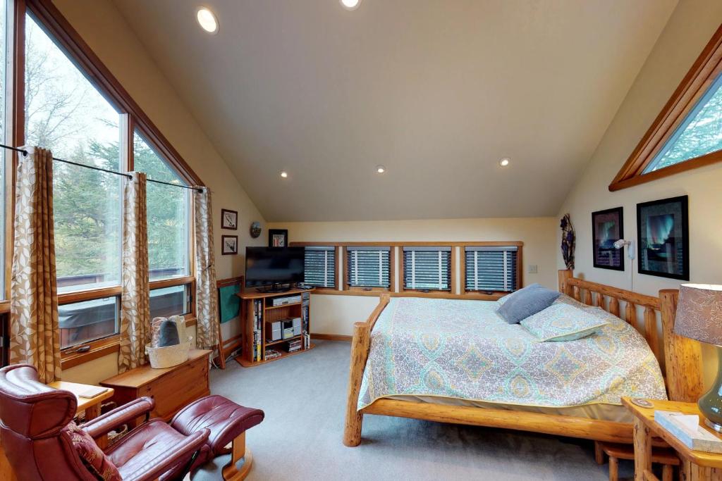 a bedroom with a bed and some windows at Crow Creek in Girdwood