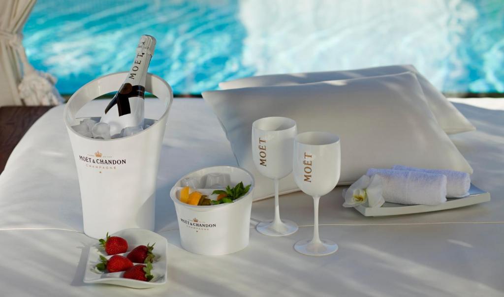 a table with two wine glasses and a bowl of fruit at Hotel Don Pepe Gran Meliá in Marbella