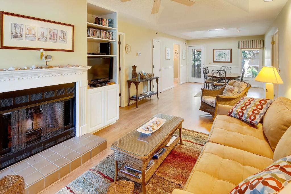 a living room with a couch and a fireplace at 1140 Summerwind Cottage in Seabrook Island