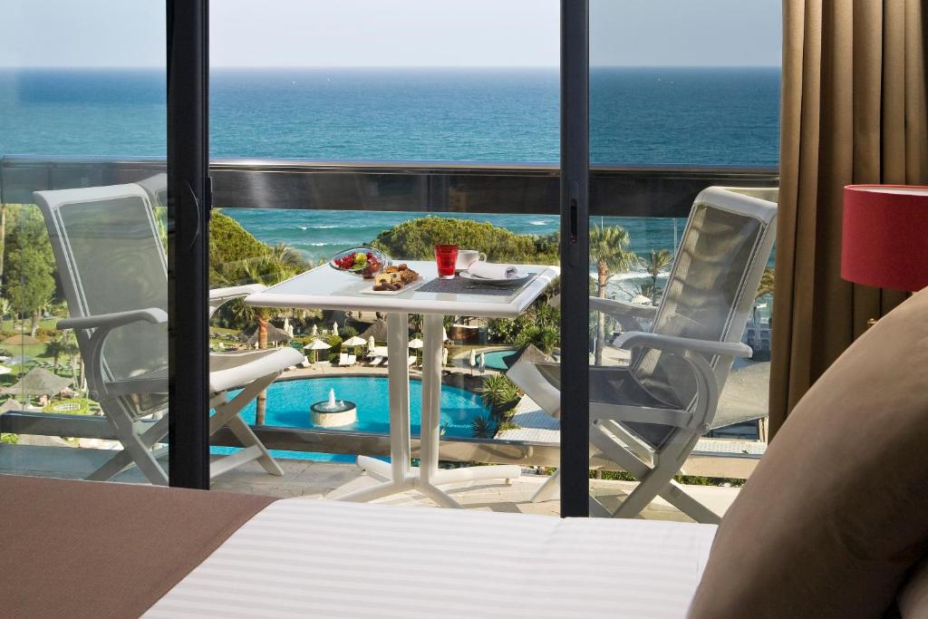 a table and chairs on a balcony with the ocean at Hotel Don Pepe Gran Meliá in Marbella