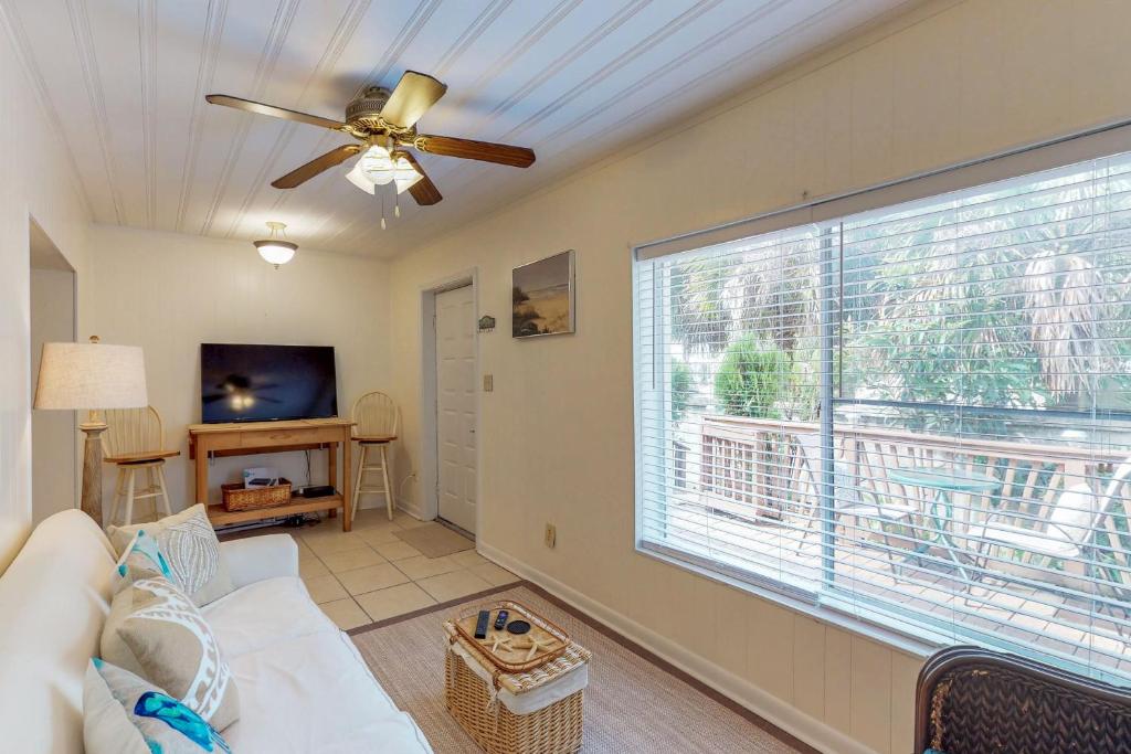 un soggiorno con ventilatore a soffitto e una grande finestra di Linda's Cozy Duplex B a Laguna Beach