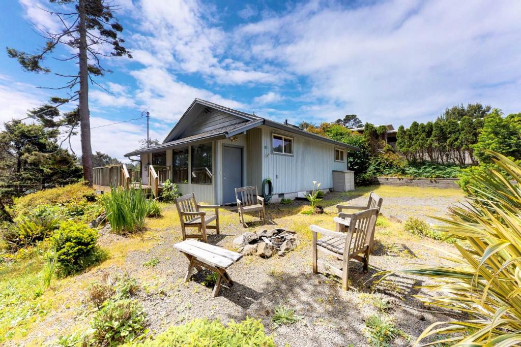 ein Haus mit einer Gruppe von Stühlen davor in der Unterkunft Sandy Cottage in Lincoln City