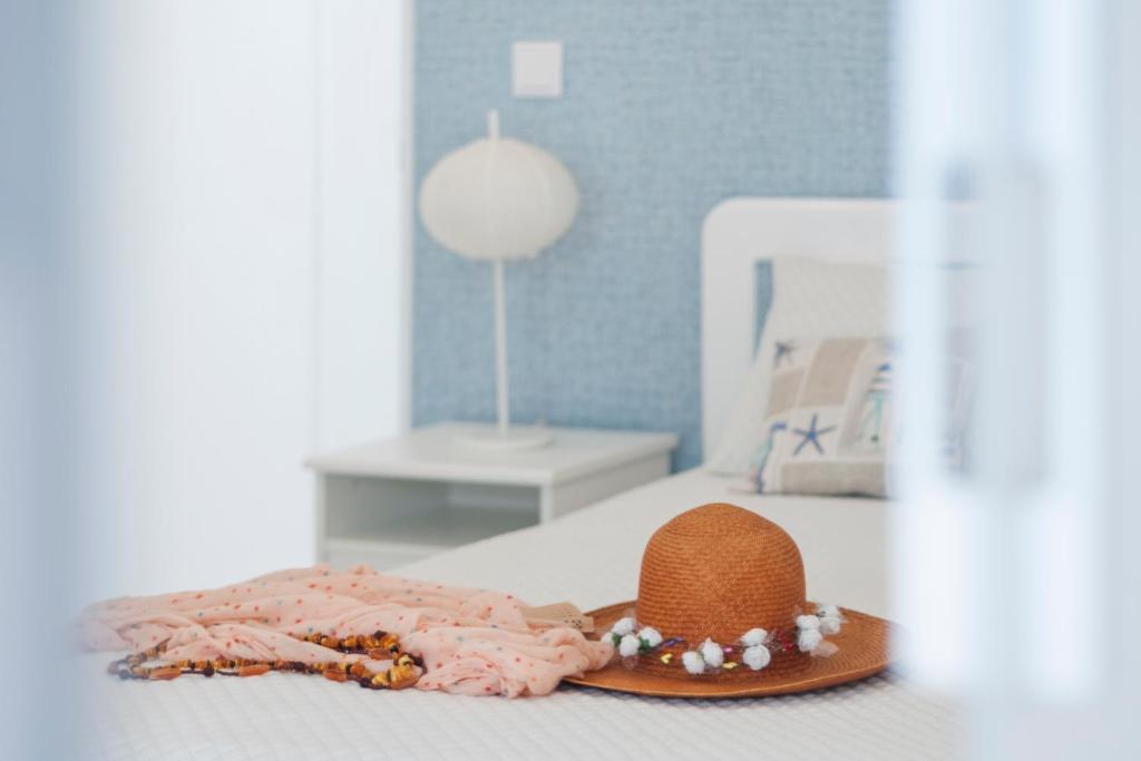 a hat and a robe on a bed at Ericeira T1 Navegantes Apartment in Ericeira