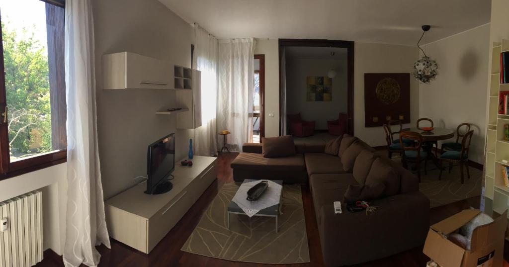 een woonkamer met een bank en een tv bij Al Centro di Metanopoli in San Donato Milanese