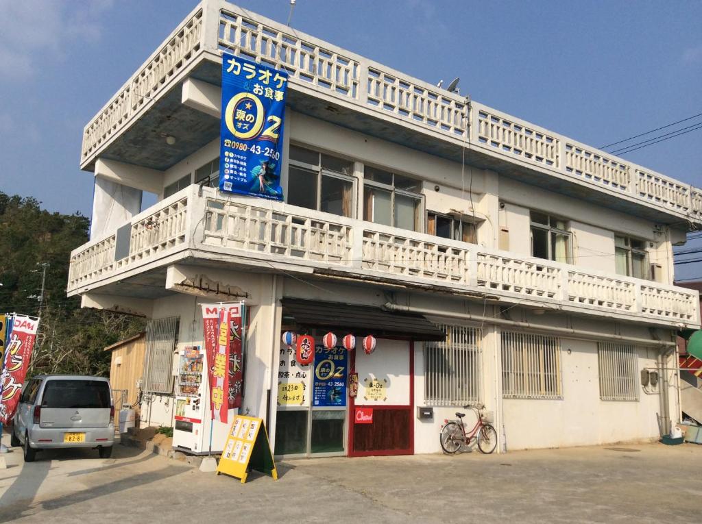ein weißes Gebäude mit Balkon darüber in der Unterkunft 東のオズ in Higashi